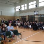 Uroczystość zakończenia roku szkolnego w Będzinie. Rodzice i uczniowie zebrali się na sali gimnastycznej.