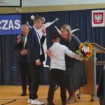 Uroczystość zakończenia roku szkolnego w Będzinie: Uczniowie otrzymują kwiaty i nagrody podczas uroczystości zakończenia roku szkolnego.
