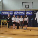 Uczniowie na uroczystości zakończenia szkoły w Będzinie. Widoczny baner „Pożegnania końca czasu”.
