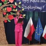 Kobieta w różowym garniturze przemawia podczas uroczystości zakończenia roku szkolnego w będzinie. „To były piękne dni. Dziękujemy!” widoczny baner.