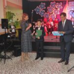 Uroczystość wręczenia nagród na zakończenie roku szkolnego w szkole w Będzinie. Uczniowie otrzymują książki.