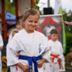 Młoda dziewczyna w karate gi z niebieskim pasem w Dożynkach Gminne Tymień.