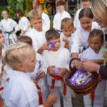 Dzieci ćwiczące karate otrzymują czekoladę w Dożynkach Gminnych Tymień.