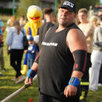 Zawodnik strongman w Dożynkach Gminne Tymień, chwytający linę.