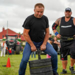 Zawodnik strongman podnoszący duże ciężary w Dożynkach Gminne Tymień 2025.