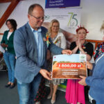 Uroczystość wręczenia nagród w Dożynkach Gminne Tymień 2025. Przedstawiono voucher o wartości 1600 zł.