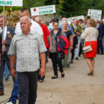 Procesja w Dożynkach Gminne Tymień 2025, w której uczestnicy niosą transparenty z napisami „Smolne” i „Solectwo Stoisław.