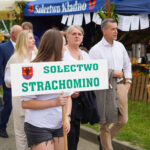 Młoda kobieta trzyma transparent wsi Strachomino na festiwalu Dożynki Gminne Tymień 2025.