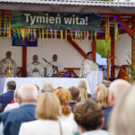 Ksiądz prowadzący Dożynki Gminne Tymień 2025 mszę św. „Tymień wita!” widoczny baner.