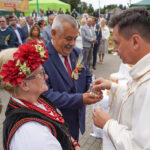 Ksiądz poświęca chleb na Dożynkach Gminnych Tymień 2025, dziękując za plony.