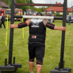 Zawodnik strongman podczas Dożynek Gminnych Tymień 2025 wykonujący zawody w podnoszeniu ciężarów.