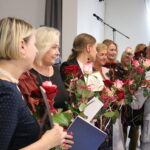 Uroczystość Dzień Edukacji Narodowej w Będzinie: kobiety z różami i dyplomami.